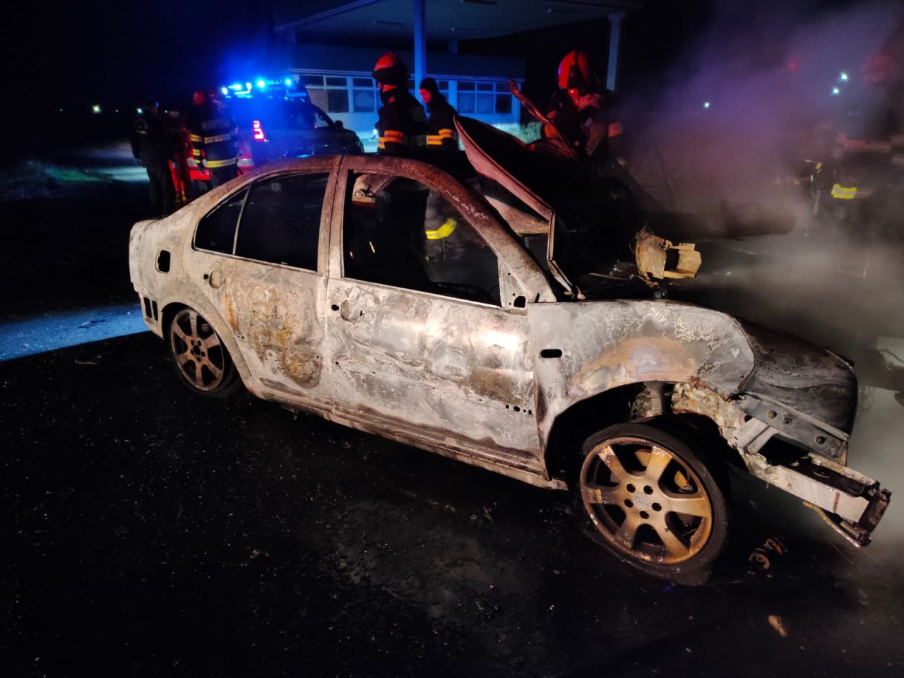 FOTO | O mașină în care se afla o tânără de 21 de ani a ars complet, după ce șoferița a intrat frontal într-un copac