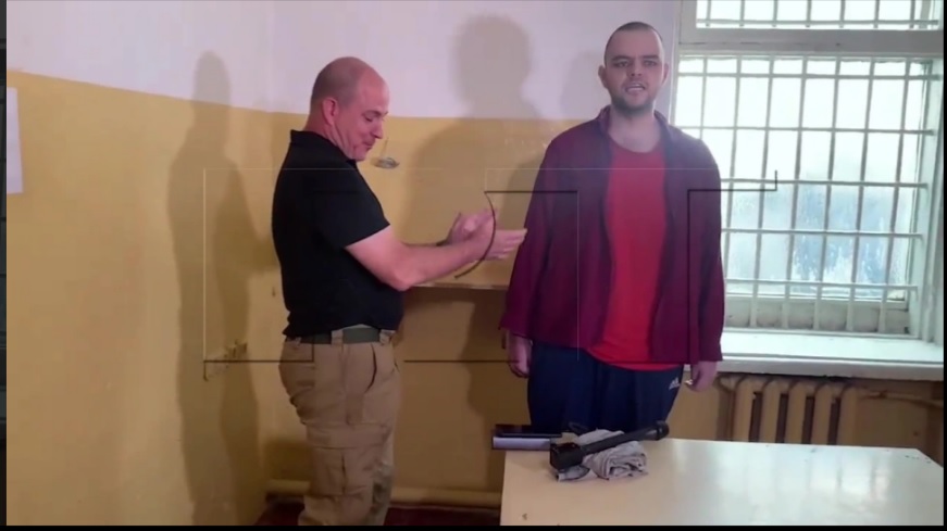 VIDEO | Soldatul britanic, capturat și condamnat la moarte de oamenii lui Vladimir Putin, forțat să cânte imnul Rusiei la televiziunea de stat