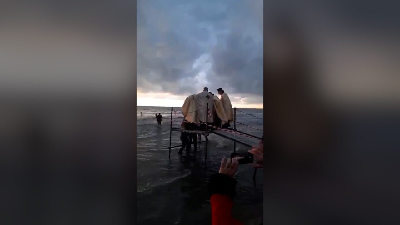 Moment inedit la malul mării: Un preot a căzut în apă în timpul slujbei de Bobotează | VIDEO