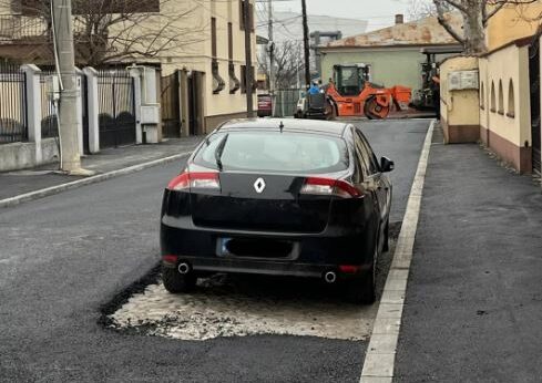 Cum au asfaltat muncitorii din CRAIOVA o stradă pe lângă o mașină parcată. „Am sunat şi la ridicări, dar și ei au întârziat”