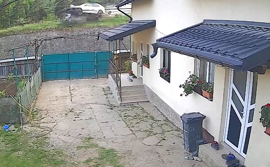 VIDEO: Accident spectaculos, surprins de camerele video. O mașină scăpată de sub control zboară de pe drum și ajunge în curtea unul localnic 